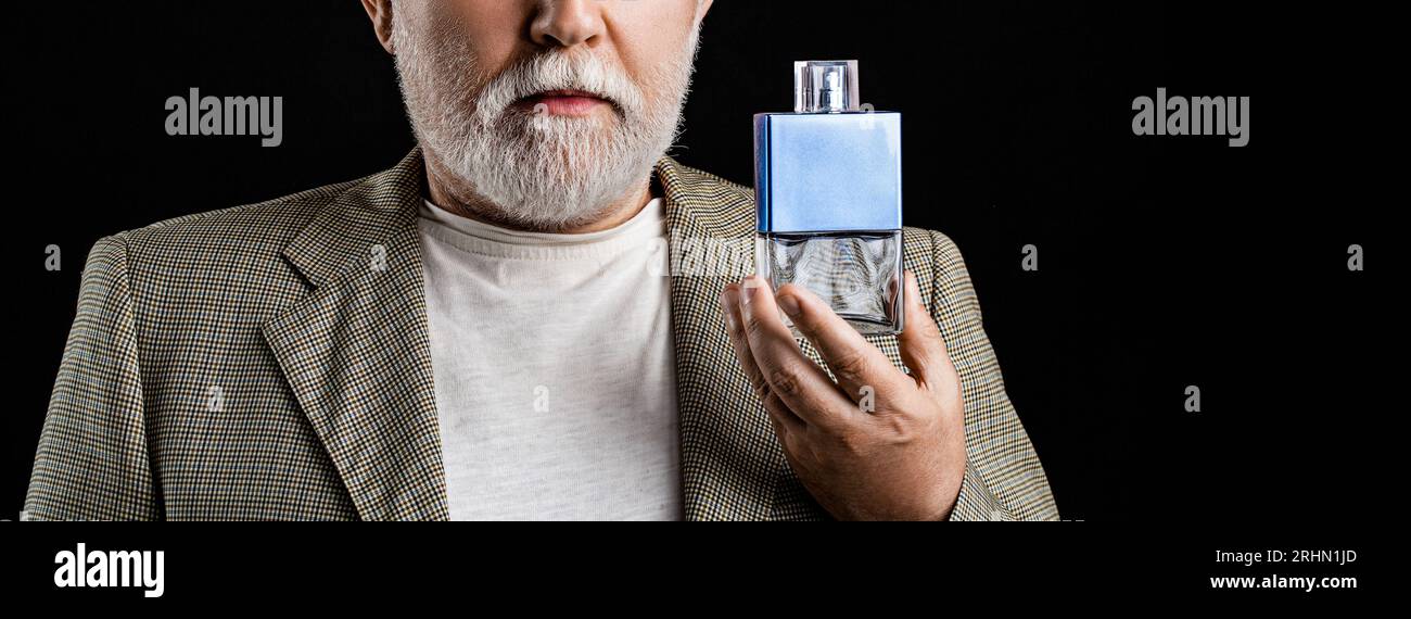 Homme tenant une bouteille de parfum. Parfum d'homme vieilli, parfum. Parfum ou bouteille de cologne parfumerie, cosmétiques, bouteille de parfum de cologne, tenue pour hommes Banque D'Images