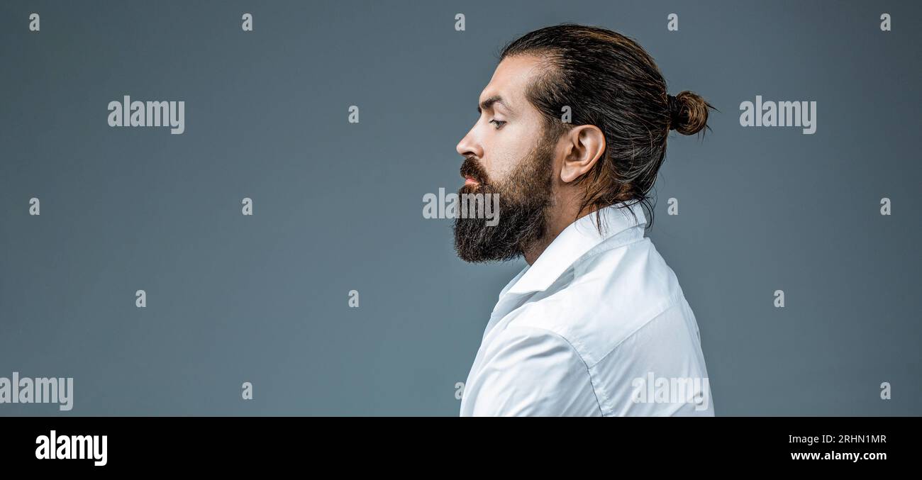 Vue latérale homme barbu isolé sur fond gris. Coupe de cheveux d'homme dans un salon de coiffure. Portrait vue de côté d'un jeune homme élégant. Barbe parfaite. Gros plan de Banque D'Images