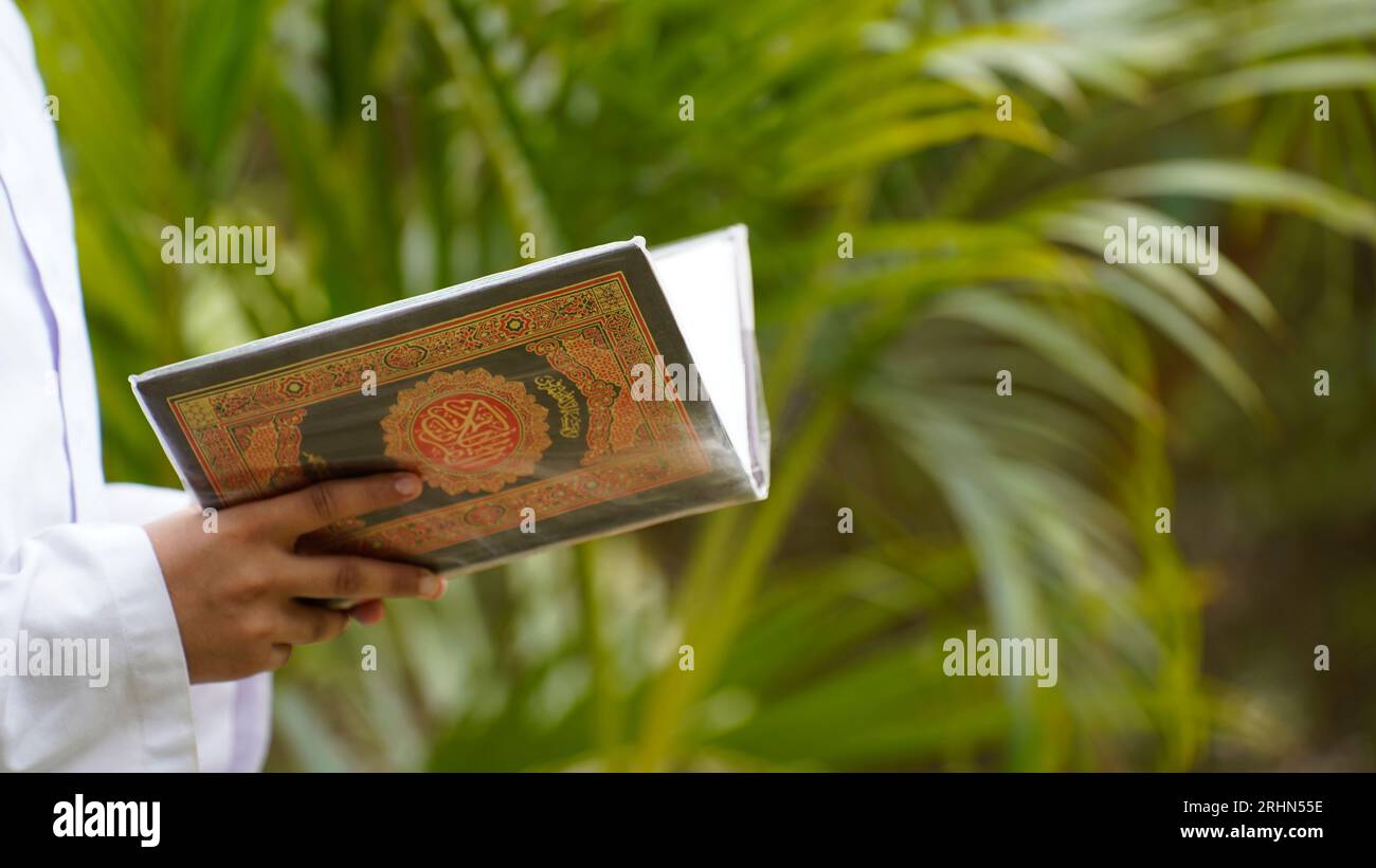 Tenir et lire le Coran, le livre sacré islamique Banque D'Images