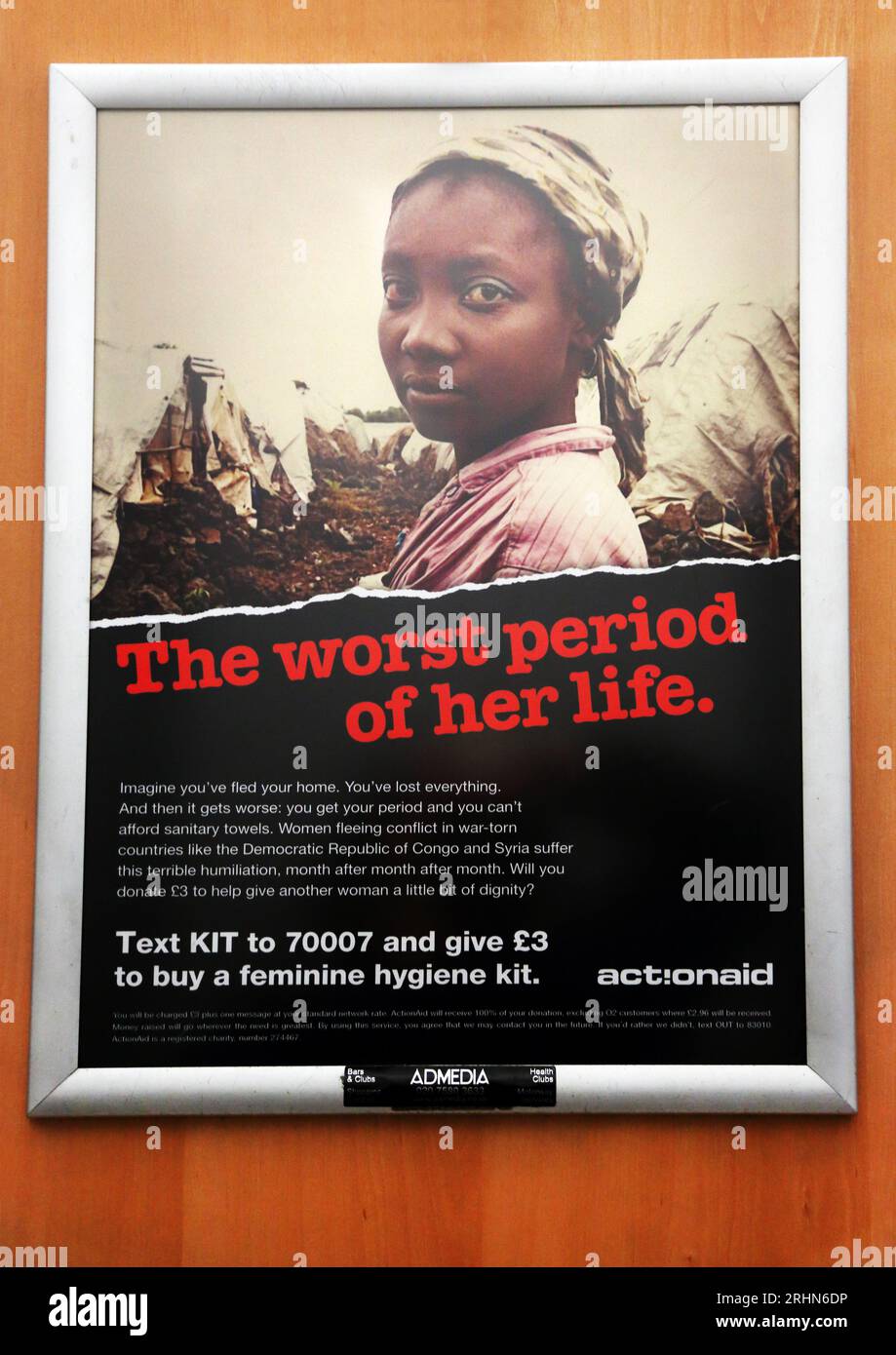 Publicité caritative ActionAid demandant un don pour des kits d'hygiène féminine pour les pays déchirés par la guerre dans Service Station Toilet England Banque D'Images