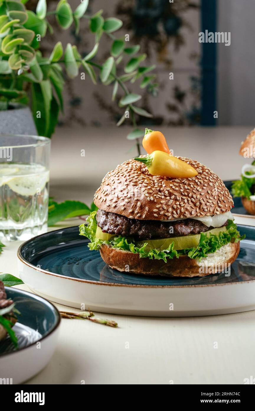 burger avec patty de bœuf haché, tomates, herbes et sauce piquante et Banque D'Images