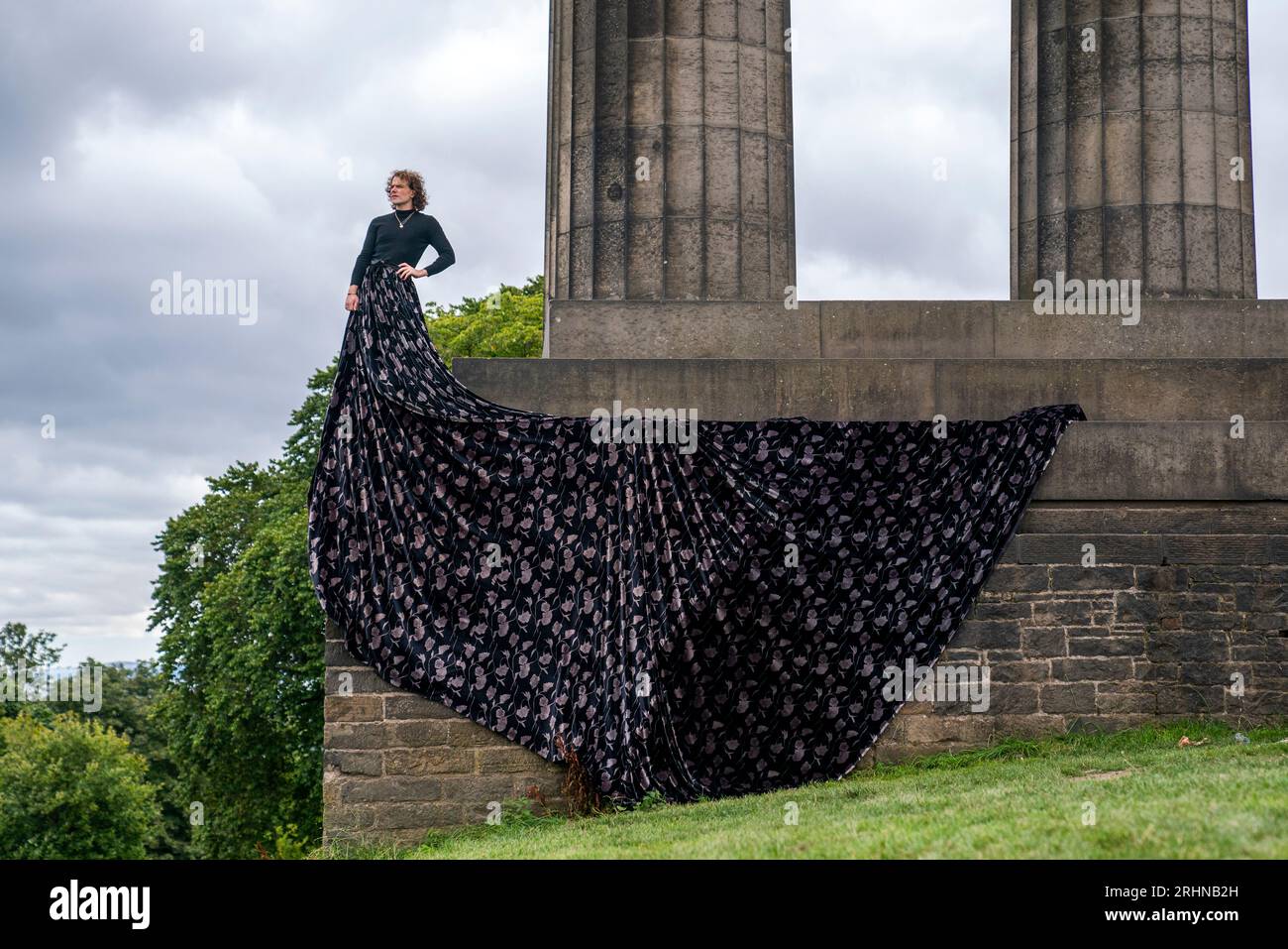 Jonny Hawkins dans le rôle de Maureen, star du spectacle du même nom au National Monument sur Calton Hill pendant le Festival Fringe d'Édimbourg. Le spectacle, qui est présenté à la Maison d'Oz du festival célèbre la sagesse et la passion des femmes âgées qui défient l'invisibilité, présente une scène qui est entièrement reprise par la fabuleuse grande jupe du personnage. Date de la photo : Vendredi 18 août 2023. Banque D'Images