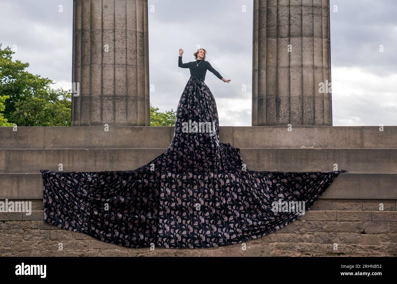 Jonny Hawkins dans le rôle de Maureen, star du spectacle du même nom au National Monument sur Calton Hill pendant le Festival Fringe d'Édimbourg. Le spectacle, qui est présenté à la Maison d'Oz du festival célèbre la sagesse et la passion des femmes âgées qui défient l'invisibilité, présente une scène qui est entièrement reprise par la fabuleuse grande jupe du personnage. Date de la photo : Vendredi 18 août 2023. Banque D'Images