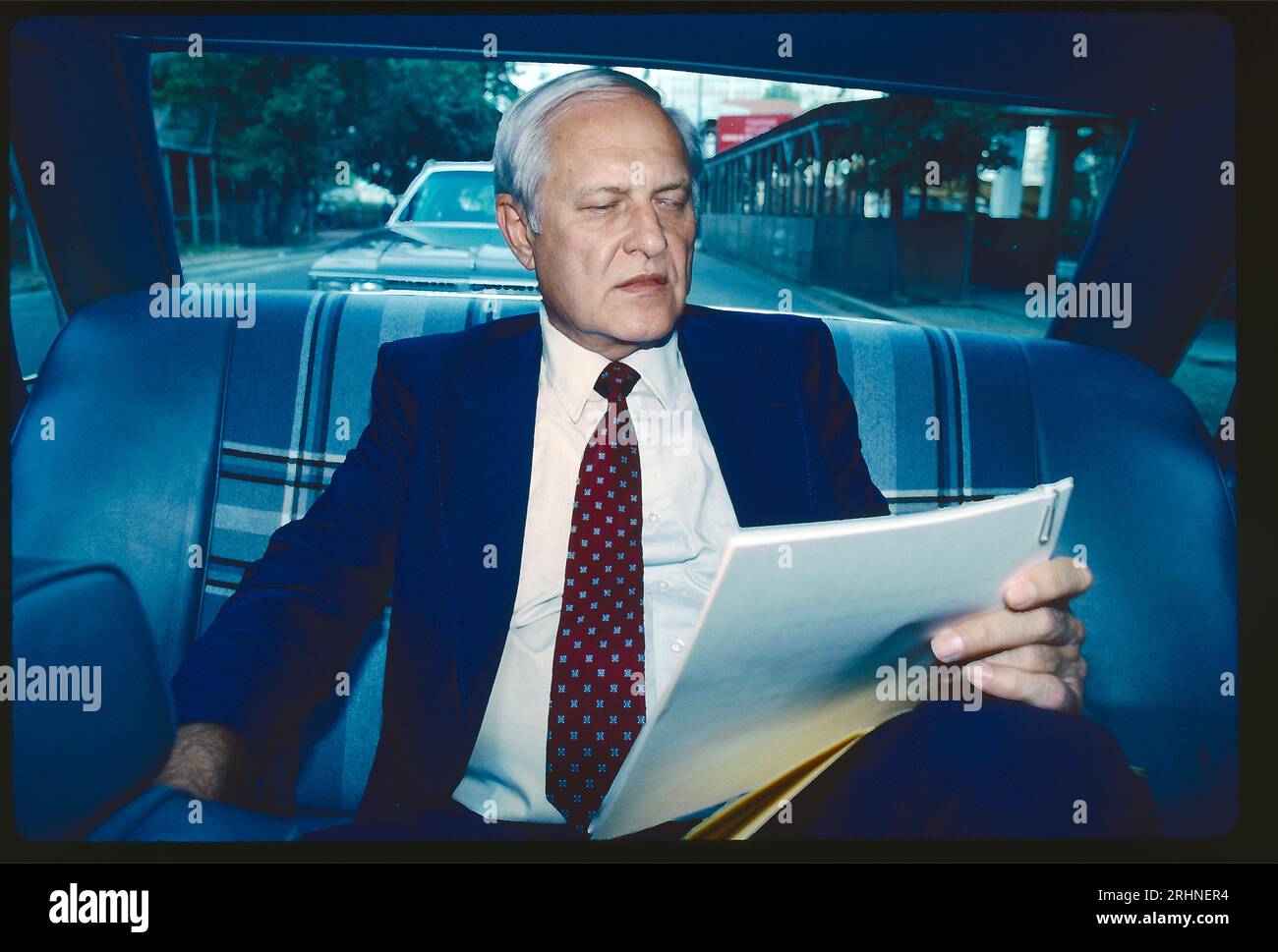 Jack Anderson, chroniqueur de journal et pionnier du journalisme d'investigation. Photographié ici à la fin des années 1970 sur le chemin de son bureau, lisant des notes sur la banquette arrière d'une voiture. Banque D'Images