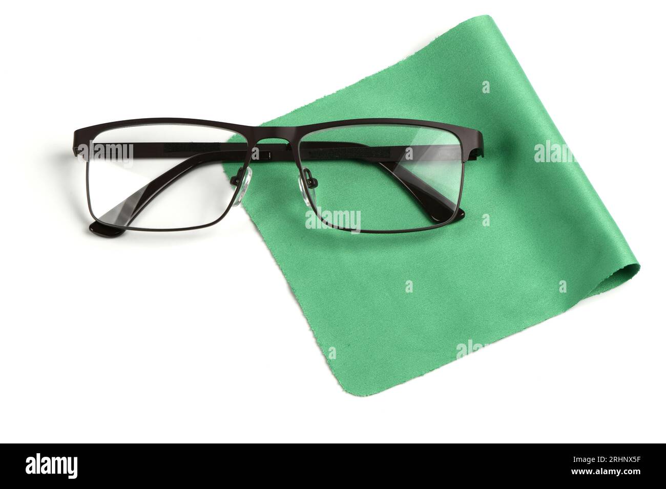 Serviette en tissu vert de nettoyage en verre avec une paire de lunettes dessus, composition isolée sur fond blanc. Photo haute résolution. Profondeur de champ totale Banque D'Images