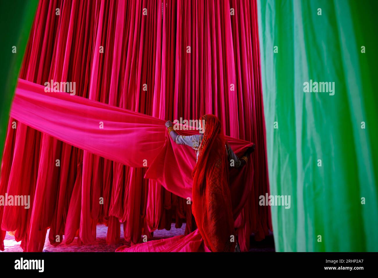 L'Inde, Rajasthan, Sari, usine textile sont séchés à l'air libre. La collecte des textiles à sec sont pliées par les femmes Banque D'Images