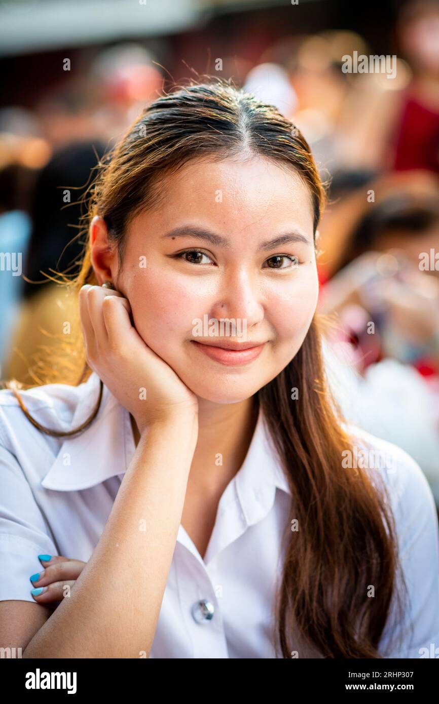 Une belle jeune fille thaïlandaise sourit pour mon appareil photo tout en déjeunant sur Yaowarat Rd. China Town, Bangkok, Thaïlande. Banque D'Images