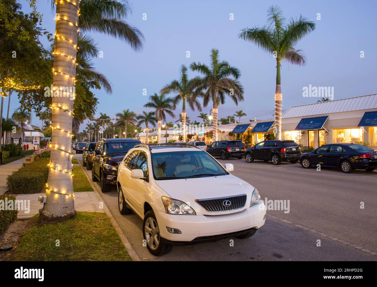 Naples, Floride, États-Unis. Vue le long de la 13th Avenue South bordée de palmiers, au cœur du quartier gastronomique de premier choix de la ville, le crépuscule. Banque D'Images