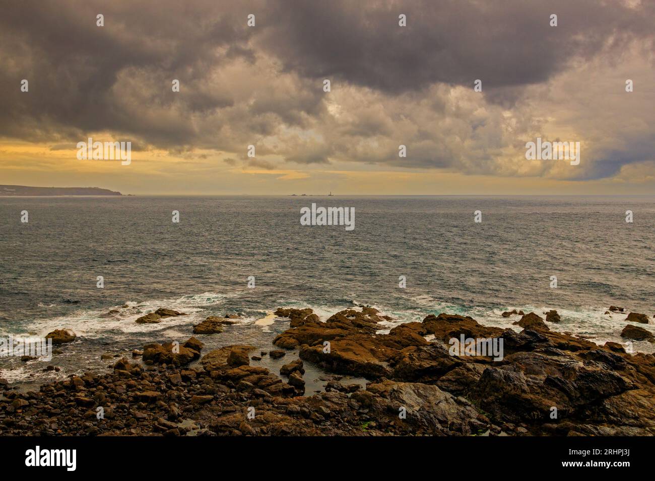 Vue vers le sud depuis le cap Cornwall vers LANd's End et le phare de Longships sous des nuages sombres et spectaculaires, Cornwall, Angleterre, Royaume-Uni Banque D'Images