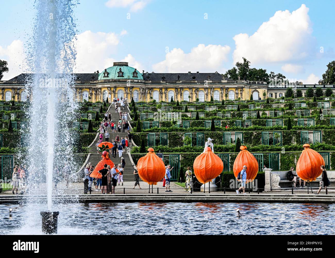 Potsdam, Allemagne. 18 août 2023. Le groupe Naranja divertit les visiteurs devant les terrasses des vignobles du château lors de la 25e nuit du château de Potsdam dans le parc de Sanssouci, qui a lieu les 18 et 19 août. Avec le titre 'prachtig' une touche néerlandaise a été donnée au programme. Un monde de conte de fées de danse, théâtre, musique, acrobaties, lectures, des installations lumineuses et des délices culinaires seront proposés dans le parc du palais de Sanssouci. Crédit : Jens Kalaene/dpa/Alamy Live News Banque D'Images