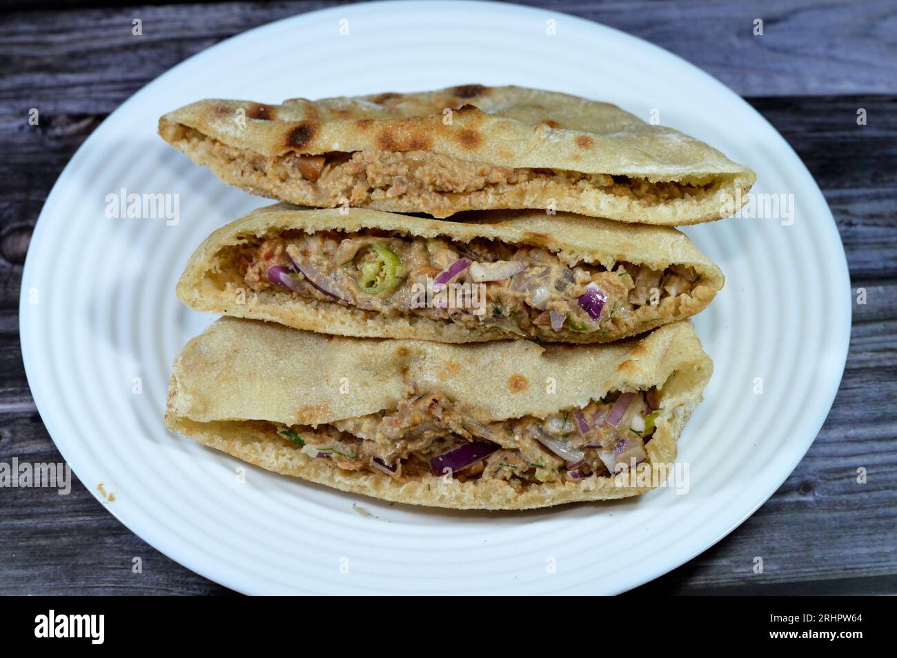 Un pain plat avec des fèves de fava écrasées mélangées à l'huile, tahini de sésame, cumin, épices, tranches de piment et d'oignon, foyer sélectif de la pop traditionnelle Banque D'Images