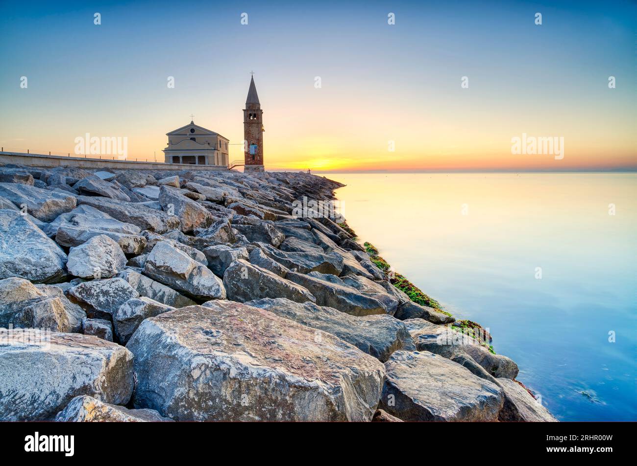 Alba sulla costa e spiaggia di Caorle, mare Adriatico. Chiesa della Madonna dell'Angelo. Veneto, Italia, Europa. Banque D'Images