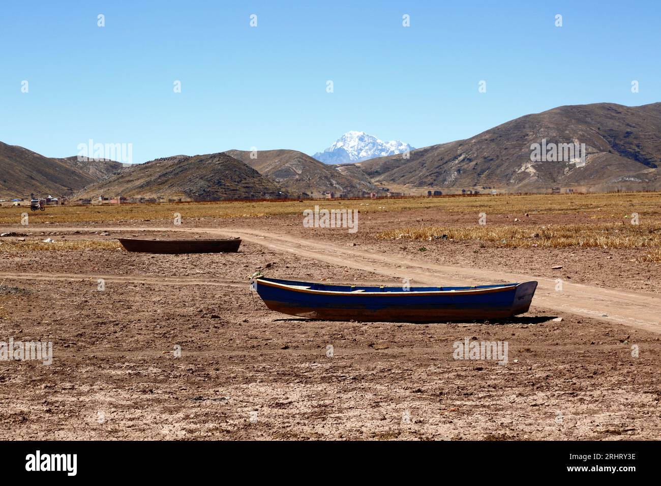 Lac Titicaca, BOLIVIE ; 18 août 2023 : bateaux à rames en bois sur la rive asséchée de la baie de Cohana sur le lac intérieur / Huiñay Marka (la plus petite partie du lac Titicaca) près du village de Cohana. En arrière-plan, le Mont Huayna Potosi (6088m) dans la Cordillère réelle des Andes. Les niveaux d'eau dans le lac Titicaca approchent du niveau record établi en 1996, le plus bas depuis que le service météorologique bolivien (Senhami) a commencé à tenir des registres en 1974. Beaucoup blâment le changement climatique ; les dernières années ont été plus sèches que la normale et El Niño se renforce actuellement dans l’océan Pacifique au large du Sud Banque D'Images Lac Titicaca, BOLIVIE ; 18 août 2023 : bateaux à rames en bois sur la rive asséchée de la baie de Cohana sur le lac intérieur / Huiñay Marka (la plus petite partie du lac Titicaca) près du village de Cohana. En arrière-plan, le Mont Huayna Potosi (6088m) dans la Cordillère réelle des Andes. Les niveaux d'eau dans le lac Titicaca approchent du niveau record établi en 1996, le plus bas depuis que le service météorologique bolivien (Senhami) a commencé à tenir des registres en 1974. Beaucoup blâment le changement climatique ; les dernières années ont été plus sèches que la normale et El Niño se renforce actuellement dans l’océan Pacifique au large du Sud Banque D'Images