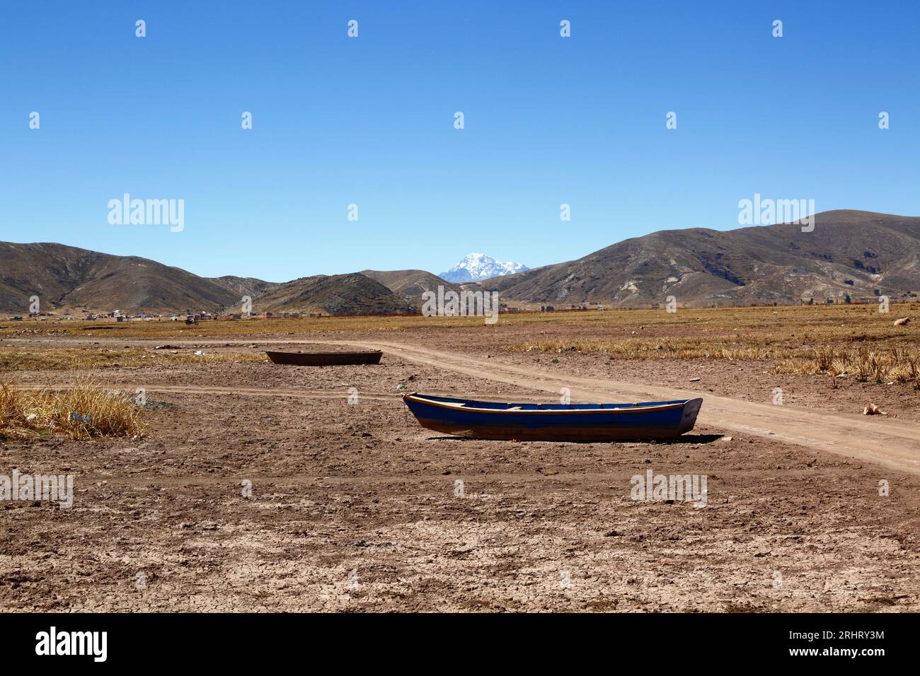 Lac Titicaca, BOLIVIE ; 18 août 2023 : bateaux à rames en bois sur la rive asséchée de la baie de Cohana sur le lac intérieur / Huiñay Marka (la plus petite partie du lac Titicaca) près du village de Cohana. En arrière-plan, le Mont Huayna Potosi (6088m) dans la Cordillère réelle des Andes. Les niveaux d'eau dans le lac Titicaca approchent du niveau record établi en 1996, le plus bas depuis que le service météorologique bolivien (Senhami) a commencé à tenir des registres en 1974. Beaucoup blâment le changement climatique ; les dernières années ont été plus sèches que la normale et El Niño se renforce actuellement dans l’océan Pacifique au large du Sud Banque D'Images Lac Titicaca, BOLIVIE ; 18 août 2023 : bateaux à rames en bois sur la rive asséchée de la baie de Cohana sur le lac intérieur / Huiñay Marka (la plus petite partie du lac Titicaca) près du village de Cohana. En arrière-plan, le Mont Huayna Potosi (6088m) dans la Cordillère réelle des Andes. Les niveaux d'eau dans le lac Titicaca approchent du niveau record établi en 1996, le plus bas depuis que le service météorologique bolivien (Senhami) a commencé à tenir des registres en 1974. Beaucoup blâment le changement climatique ; les dernières années ont été plus sèches que la normale et El Niño se renforce actuellement dans l’océan Pacifique au large du Sud Banque D'Images