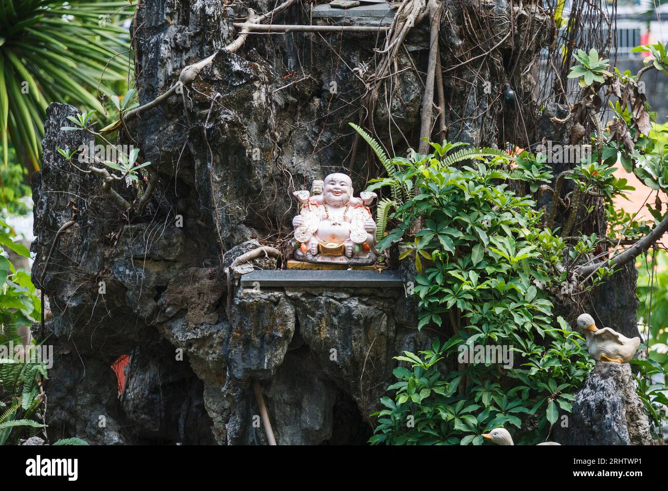 Petite statue de Bouddha dans l'arbre à Saigon Banque D'Images