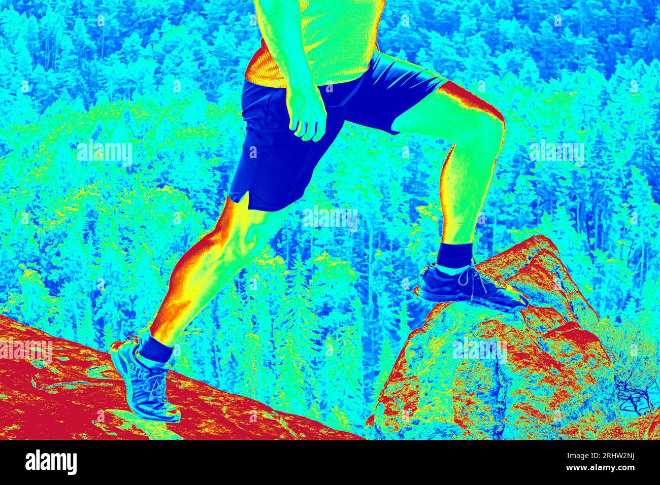 Longues jambes en chaussures de randonnée au pic. Randonnée dans les roches de grès,. Photo thermographique étonnante de paysage vallonné. Banque D'Images