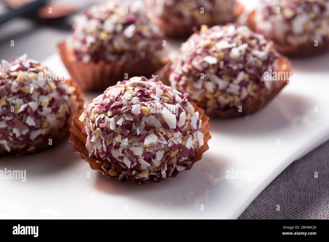 Onde-onde ketan Hitam ou boule de sésame de riz gluant noir, servie sur une assiette Bali traditionnelle indonésienne. Gros plan. Snack indonésien populaire Banque D'Images