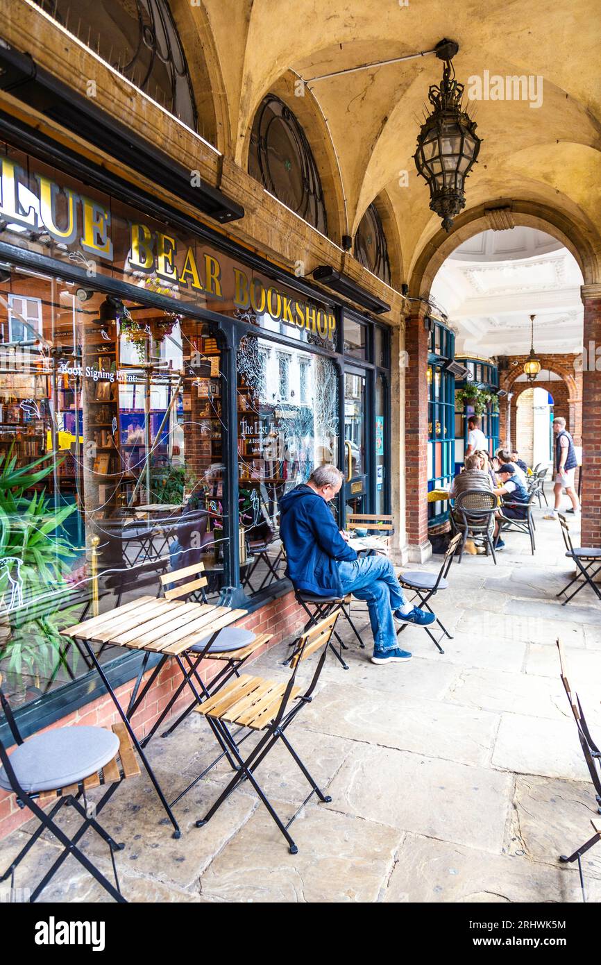 Homme prenant un café devant la librairie Blue Bear dans la mairie et Corn Exchange arcades, Farnham, Surrey, Angleterre Banque D'Images
