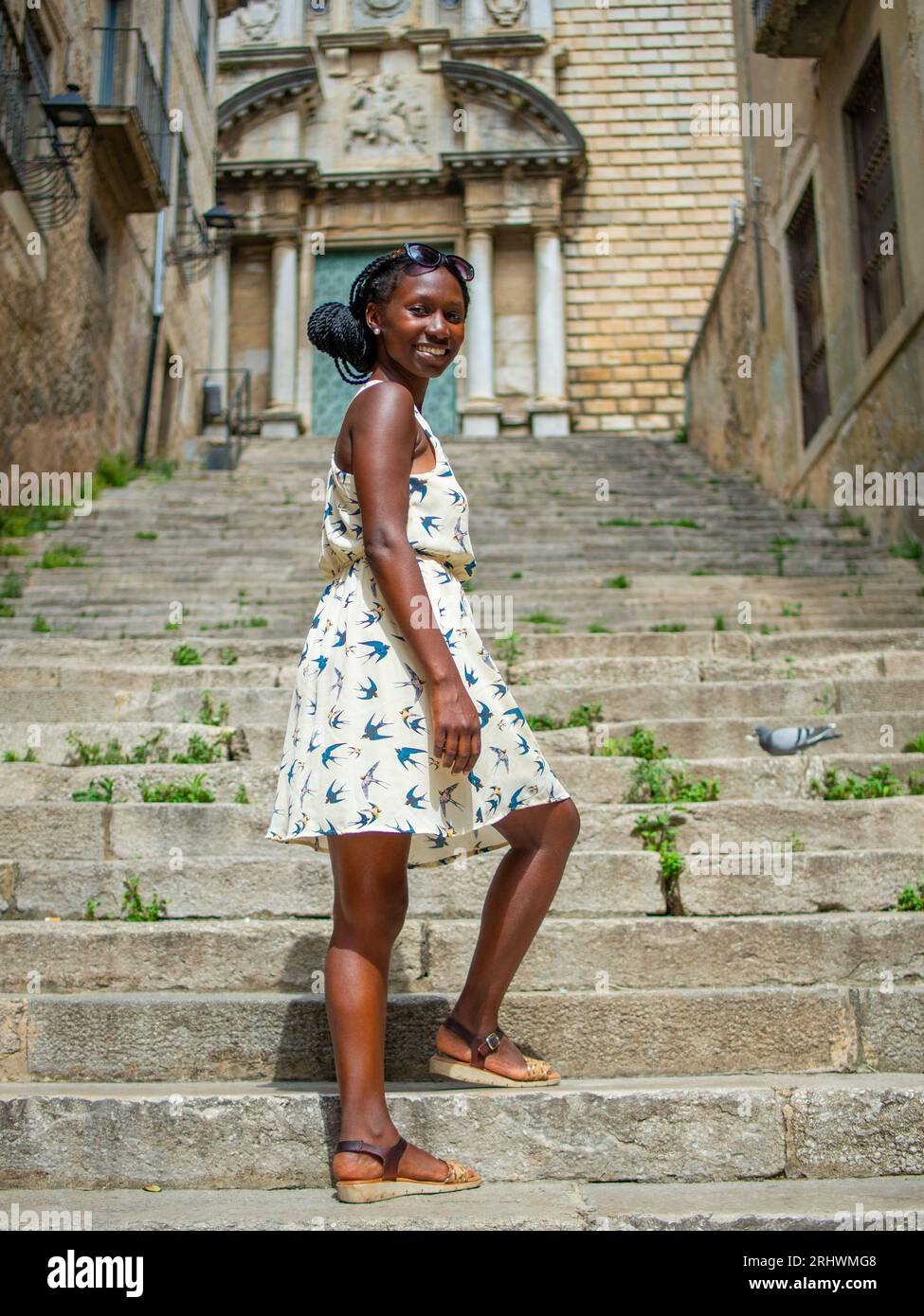 Jeune femme posant pour une photo dans un bâtiment emblématique à Gérone en Espagne Banque D'Images
