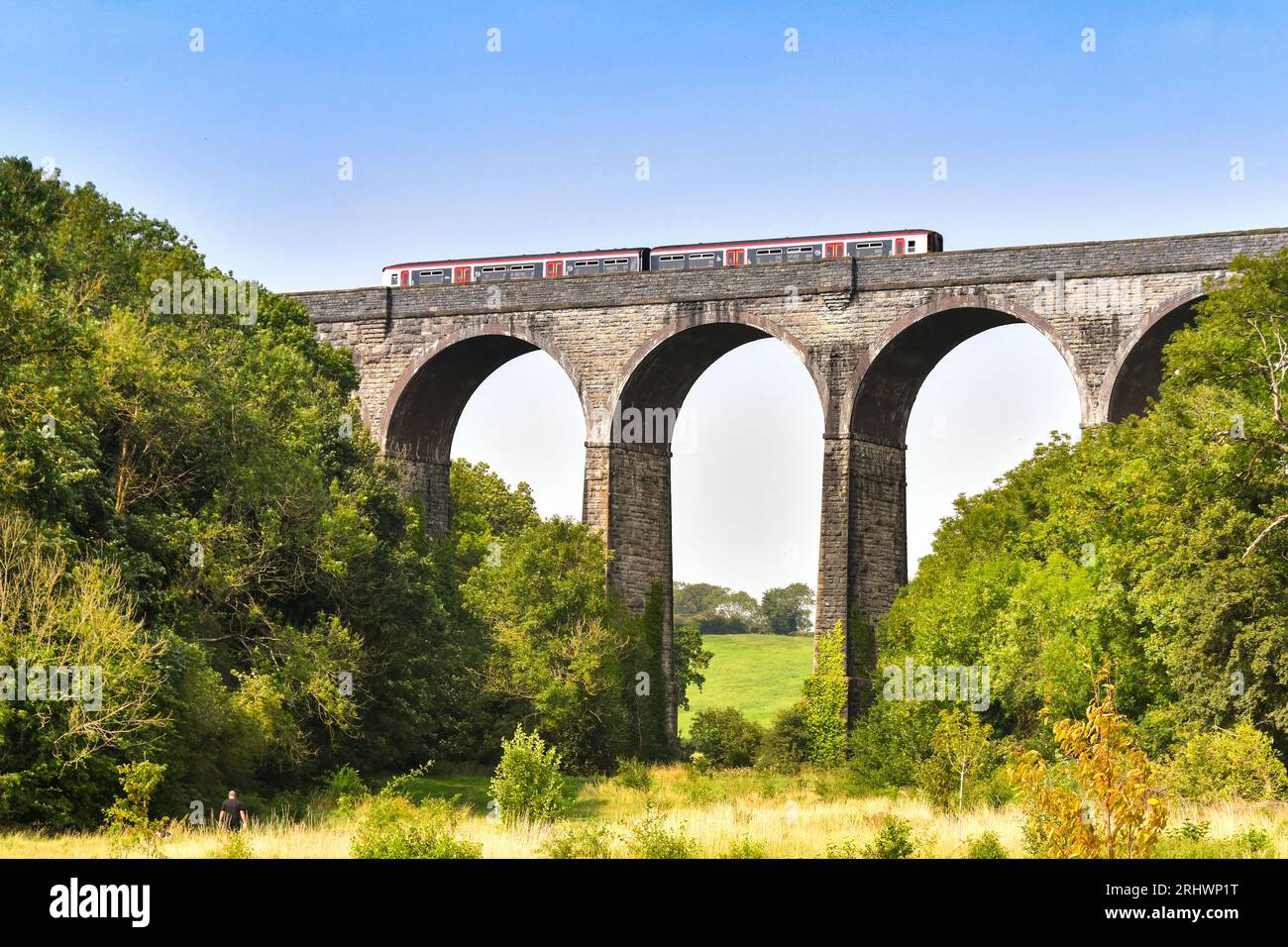 Barry, pays de Galles - 17 août 2023 : train de banlieue exploité par transport for Wales traversant le viaduc de pierre sur Porthkerry Country Psrk dans le sud du pays de Galles Banque D'Images