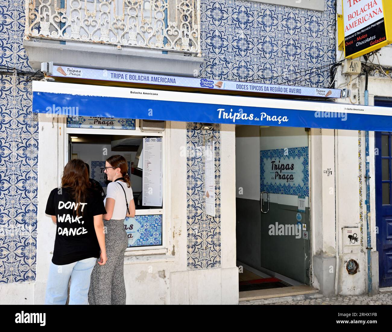 Les femmes clientes à la fenêtre à l'extérieur du stalle vendant le sucré régional traditionnel Aveiro "tripas", semblable à un crape ou une crêpe, Aveiro, Portugal Banque D'Images