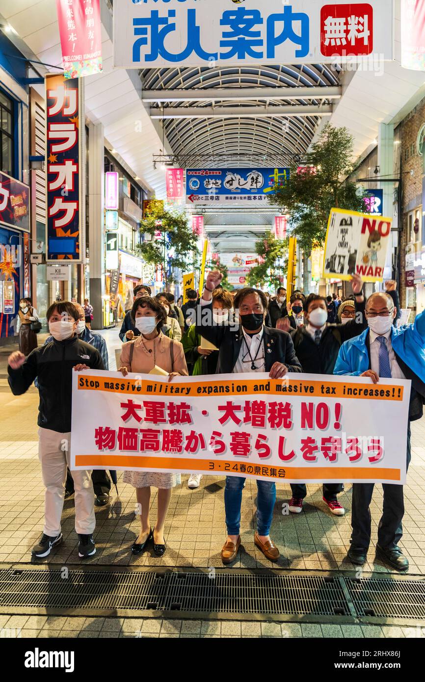 Les manifestants défilent dans une galerie marchande de Kumamoto. Japon, protestant contre la hausse de la taxe à la consommation et l'augmentation des dépenses militaires. Banque D'Images