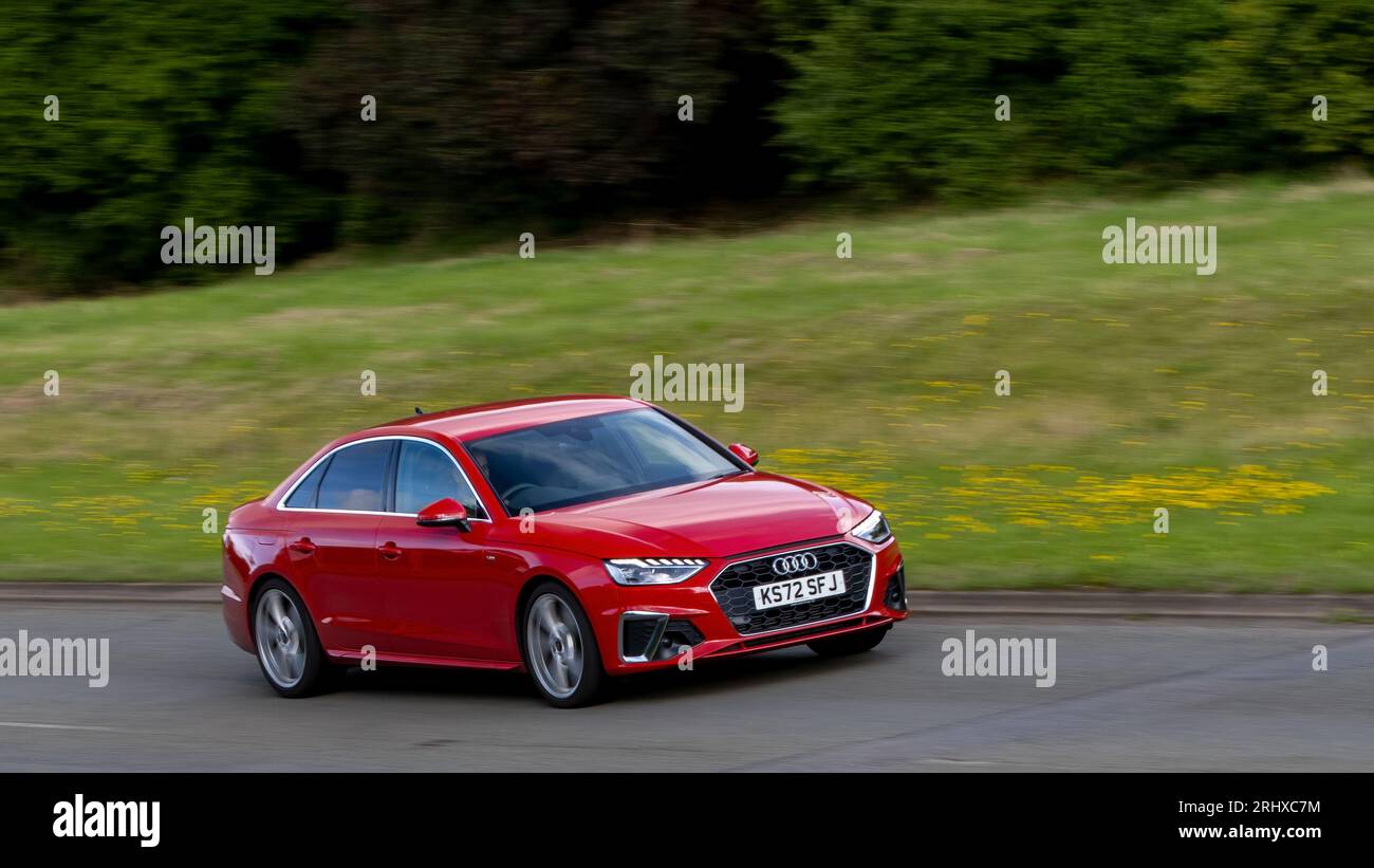 Milton Keynes, Royaume-Uni - 11 août 2023 : Red 2023 Audi A4 berline conduisant sur une route de campagne anglaise. Banque D'Images