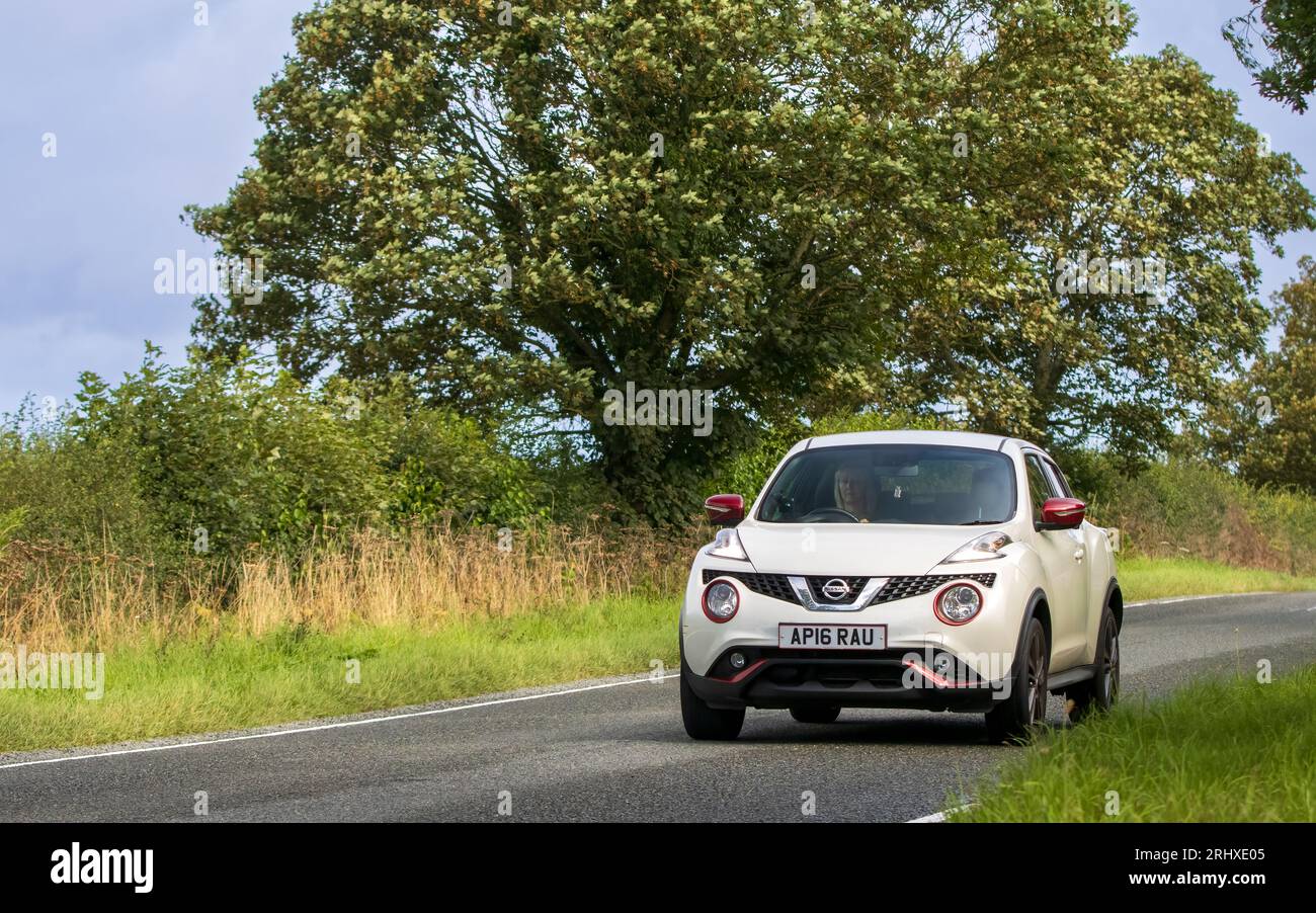 Woburn, Beds, UK - 19 août 2023 : 2016 voiture blanche Nissan juke voyageant sur une route de campagne anglaise. Banque D'Images