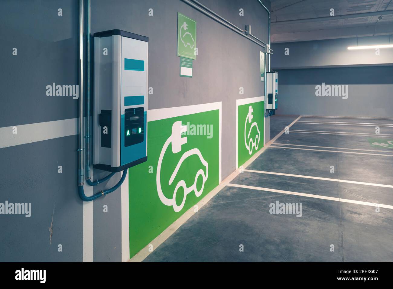 Panneaux de chargeur de voiture électrique et points de charge pour véhicules électriques sur le mur gris à la station de charge de voiture électrique Banque D'Images