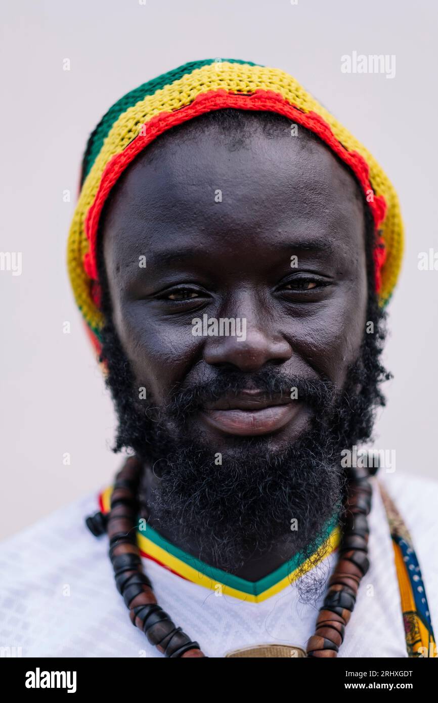 Portrait de l'homme afro-américain dans le chapeau coloré debout et regardant la caméra sur fond blanc Banque D'Images