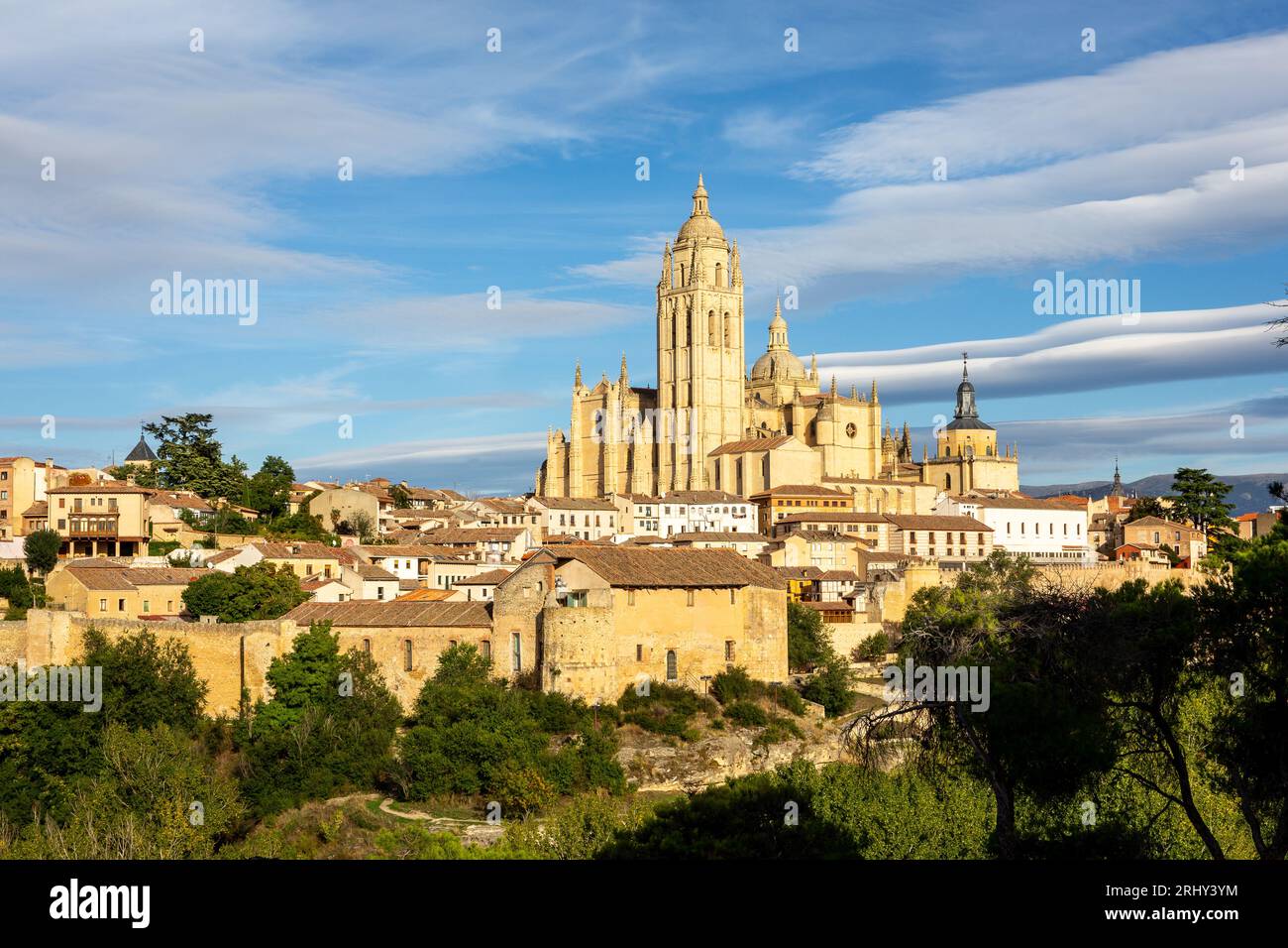 Ségovie, Espagne, paysage urbain avec cathédrale de Ségovie au sommet, clocher de l'église et architecture médiévale autour, nuages lenticulaires dans le ciel. Banque D'Images