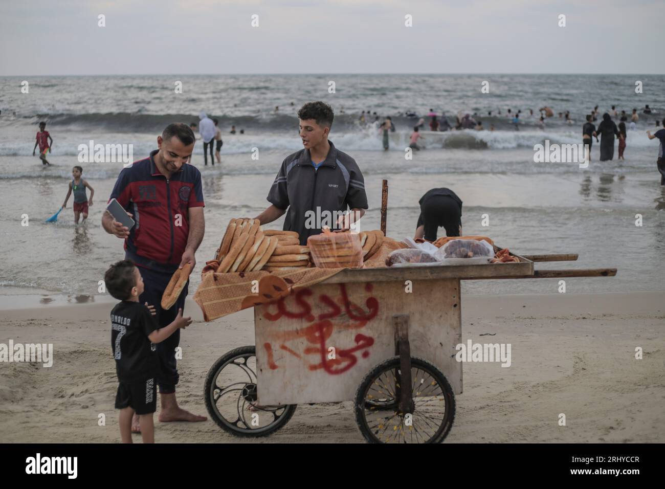 19 août 2023, ville de Gaza, la bande de Gaza, Palestine : un palestinien vend du pain sur la plage dans l'ouest de la ville de Gaza, bande de Gaza le 19 août 2023. La vie quotidienne dans la ville de Gaza au milieu de la flambée des températures et des coupures de courant pendant le blocus israélien en cours le 19 août 2023. Pour les Palestiniens vivant à Gaza, la bande de Gaza surpeuplée, la chaleur des vagues empire en été en raison des coupures de courant dues au blocus israélien continu. (Image de crédit : © Mahmoud Issa/Quds Net News via ZUMA Press Wire) USAGE ÉDITORIAL SEULEMENT! Non destiné à UN USAGE commercial ! Banque D'Images