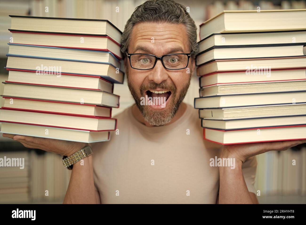 Drôle d'enseignant de tenir beaucoup de livres. Professeur fou avec des livres. Enseignant enthousiaste dans la bibliothèque de livres de l'école. Examen universitaire. Étudier enseigner à l'université. Éducateur Banque D'Images