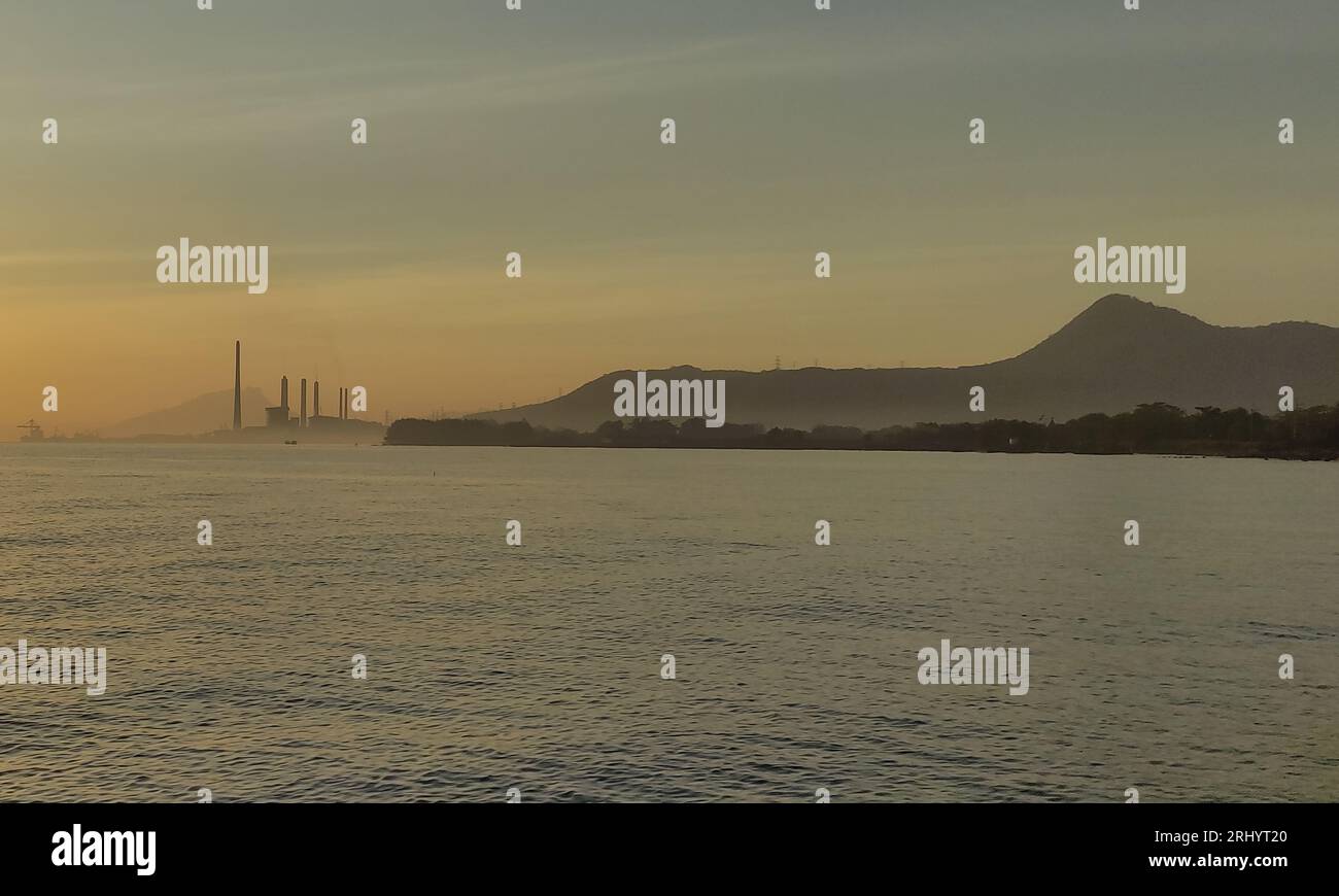 Scène de plage avec centrale à vapeur Paiton et montagnes Baluran en arrière-plan, Probolinggo, Java oriental, Indonésie Banque D'Images