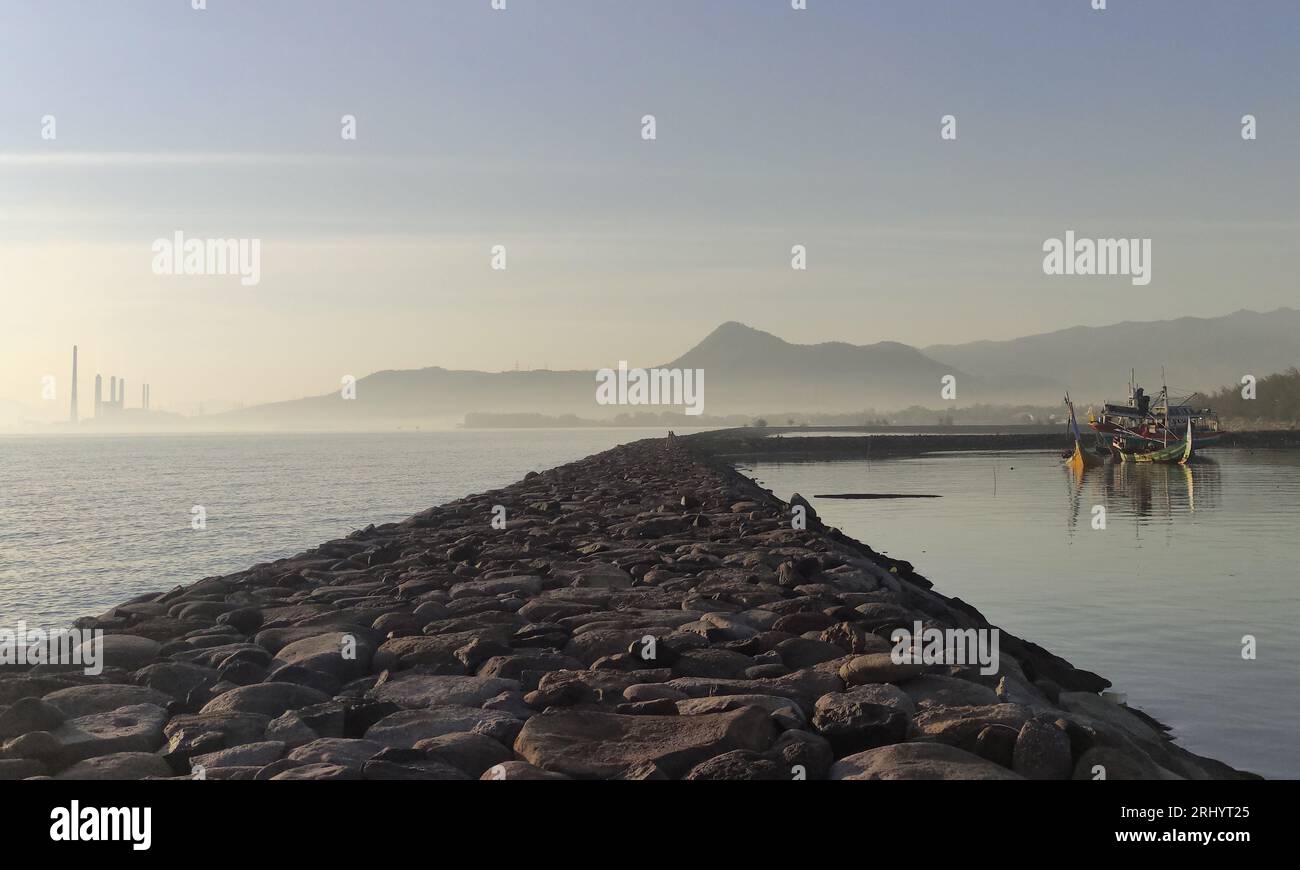Scène de plage avec centrale à vapeur Paiton et montagnes Baluran en arrière-plan, Probolinggo, Java oriental, Indonésie Banque D'Images