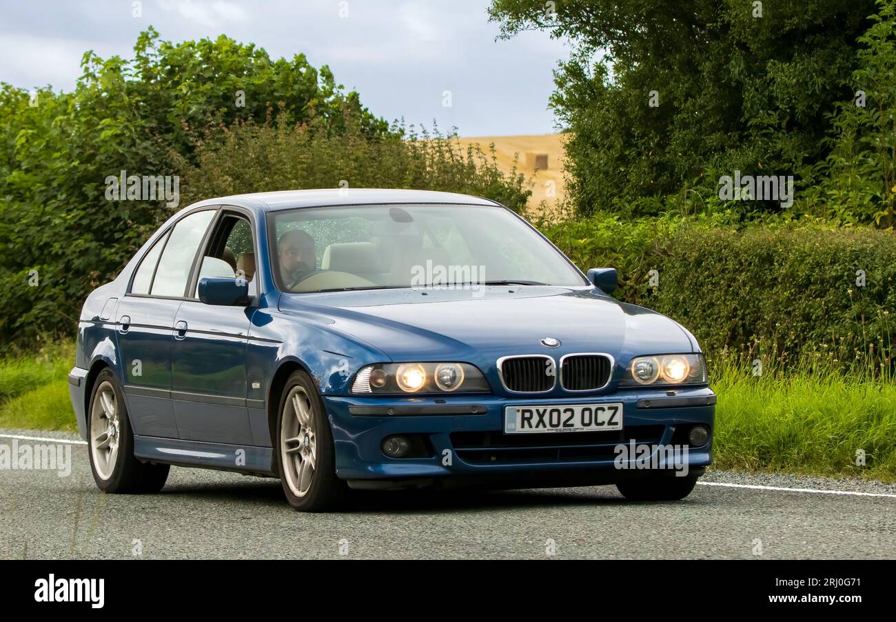 Woburn, Lits, Royaume-Uni - 19 août 2023 : 2002 voiture bleue BMW 530 voyageant sur une route de campagne anglaise. Banque D'Images