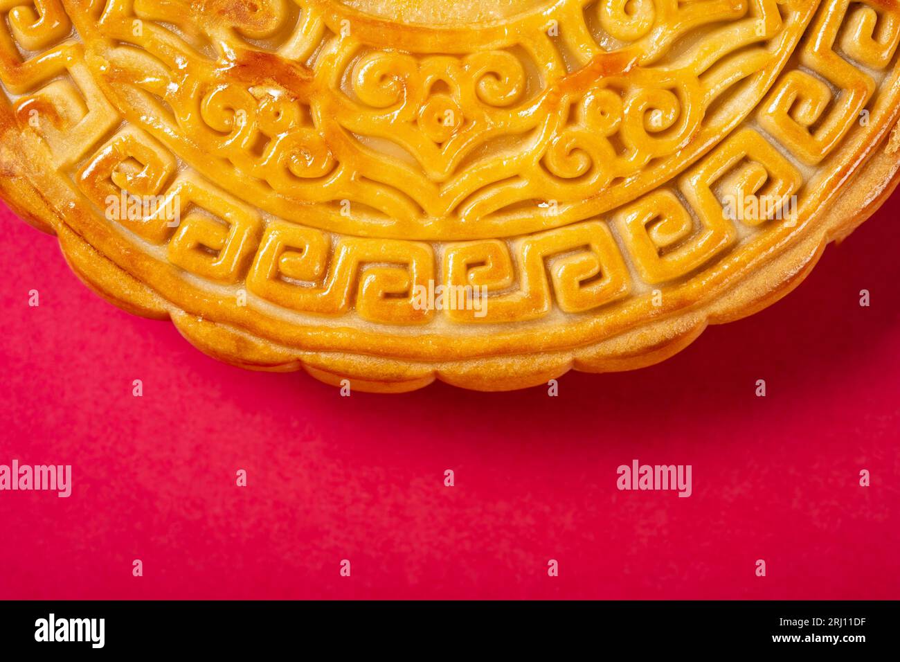 Partie d'un gâteau de lune chinois traditionnel sur rouge avec la composition horizontale de l'espace de copie Banque D'Images