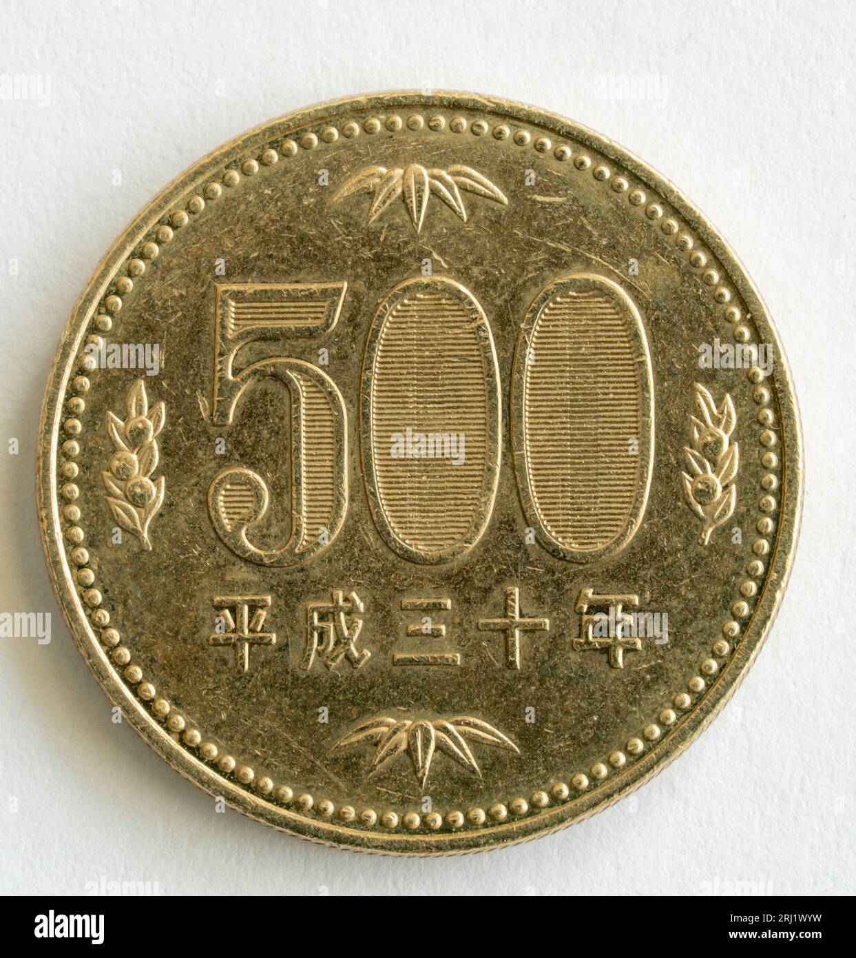 Pièce japonaise de 500 yens frappée pour l'empereur Showa, Hirohito. Il a la valeur avec des oranges mandarines sur les côtés et des feuilles de bambou au-dessus et en dessous. Banque D'Images