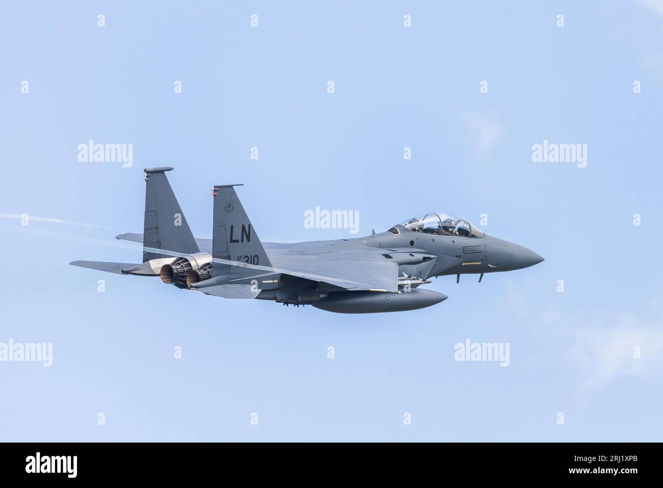 Un F-15E Strike Eagle vu avec des traînées de vapeur de ses extrémités d'aile alors qu'il décolle de sa base aérienne de l'USAF à RAF Lakenheath dans le Suffolk photographié à Augus Banque D'Images