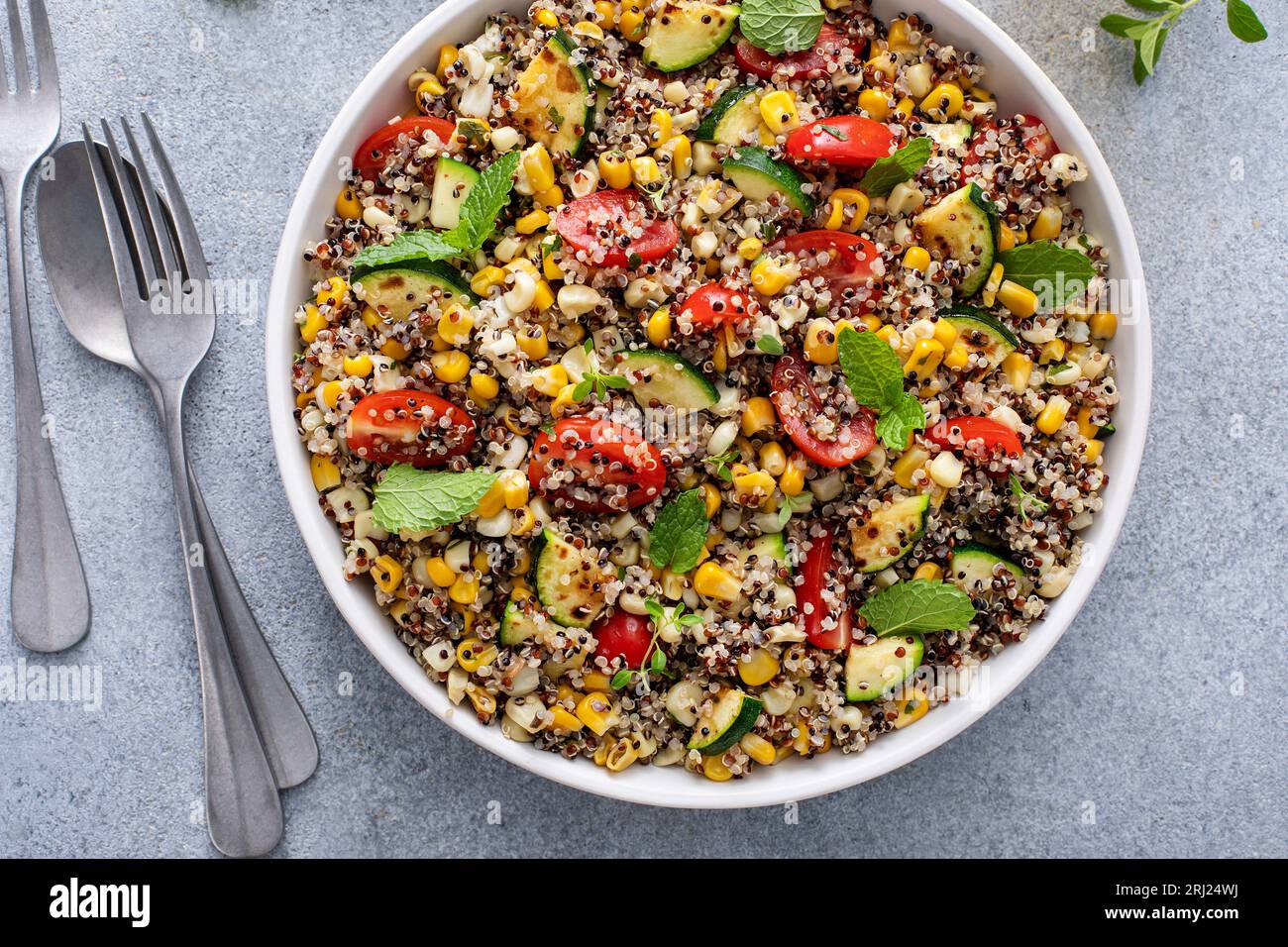 Salade tiède de quinoa avec tomates, maïs et courgettes avec menthe fraîche et herbes, coup de tête Banque D'Images