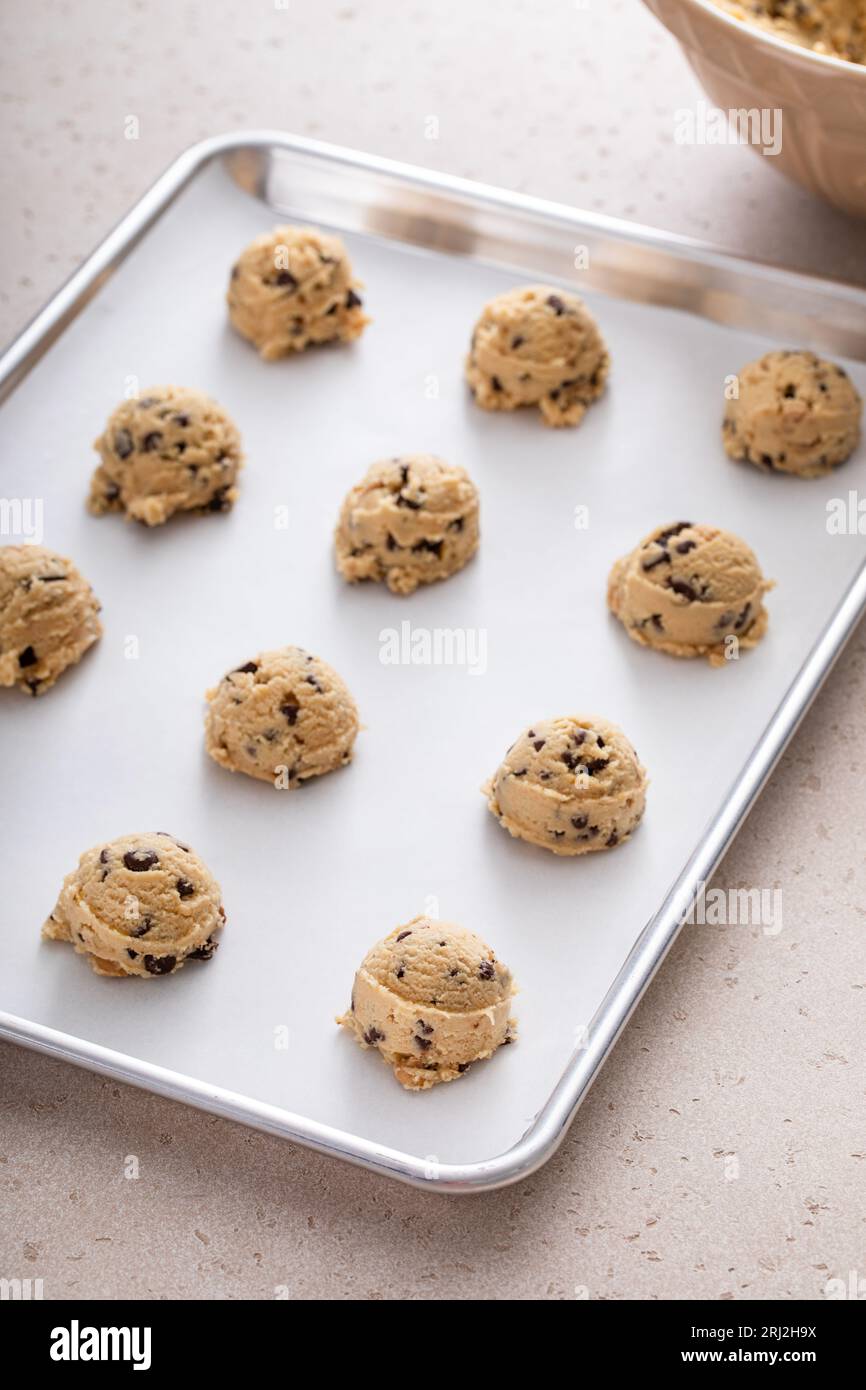 Pâte à biscuits aux pépites de chocolat cueillie sur une plaque à biscuits prête à être cuite Banque D'Images