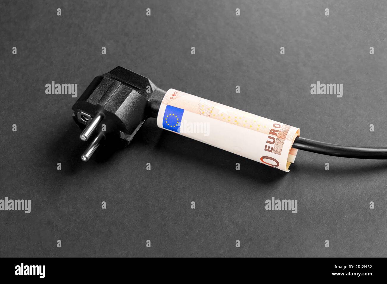 Fiche électrique avec câble noir et billet de banque en euro. Concept économique de la valeur de l'approvisionnement en électricité et de la hausse des prix Banque D'Images