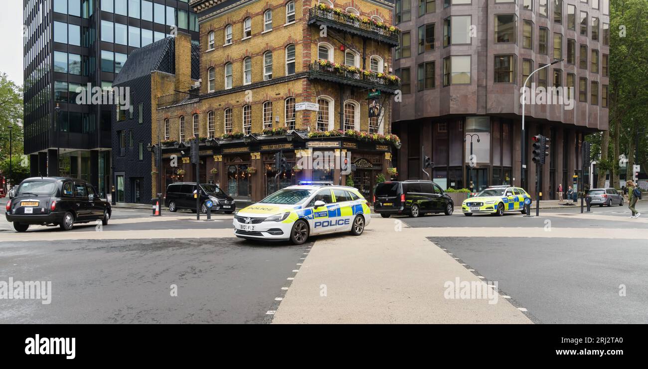Londres, Royaume-Uni - 29 juillet 2023 ; voitures de police du London Metropolitan à grande vitesse avec des feux bleus clignotant à l'intersection de la rue Banque D'Images
