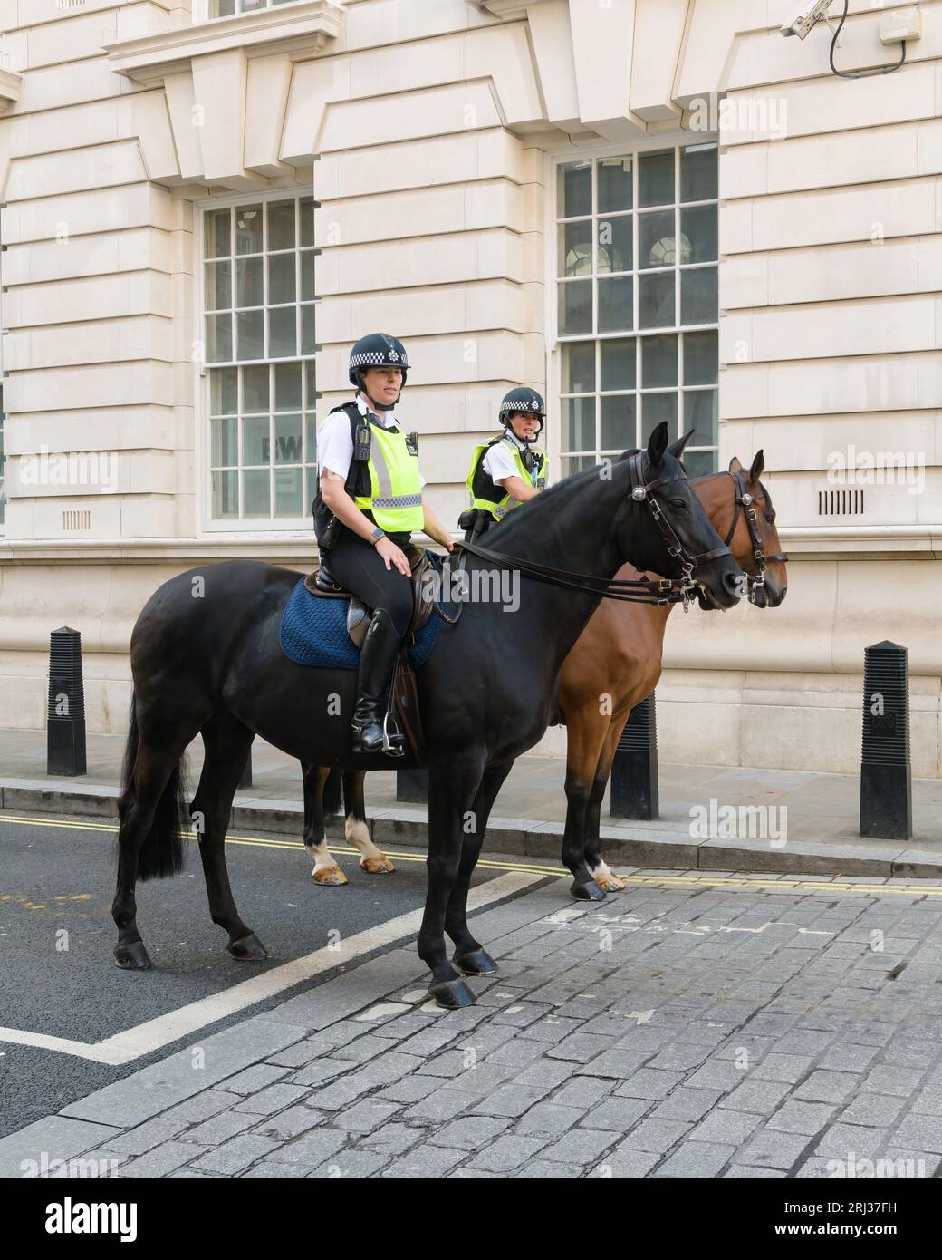 Londres, Royaume-Uni - 29 juillet 2023 ; deux policiers à cheval dans la Cité de Westminster dans la rue Banque D'Images