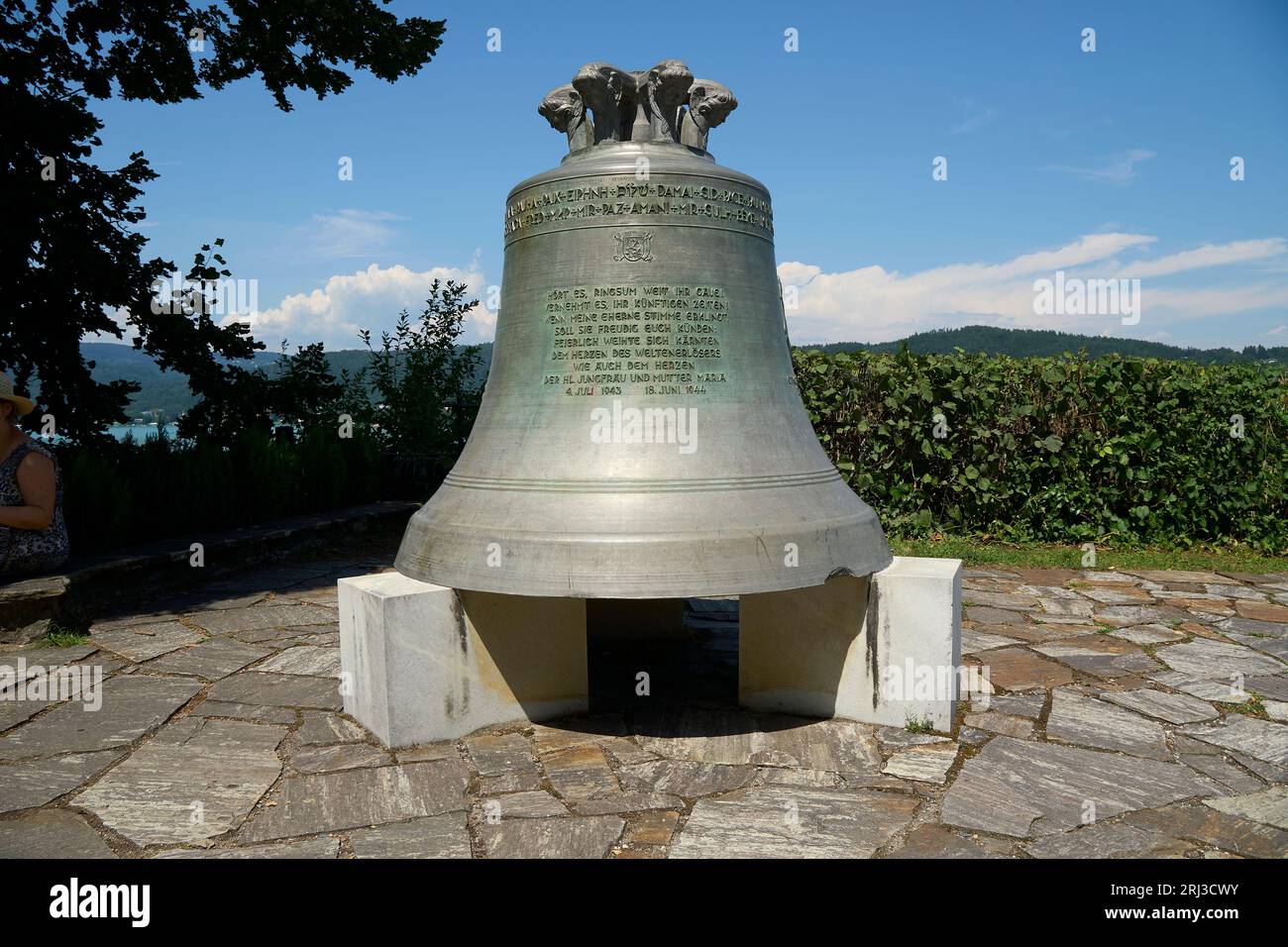 Un sentier pavé pittoresque en Carinthie, en Autriche, est le cadre d'une grande cloche antique perchée au sommet d'une pile de blocs de pierre Banque D'Images