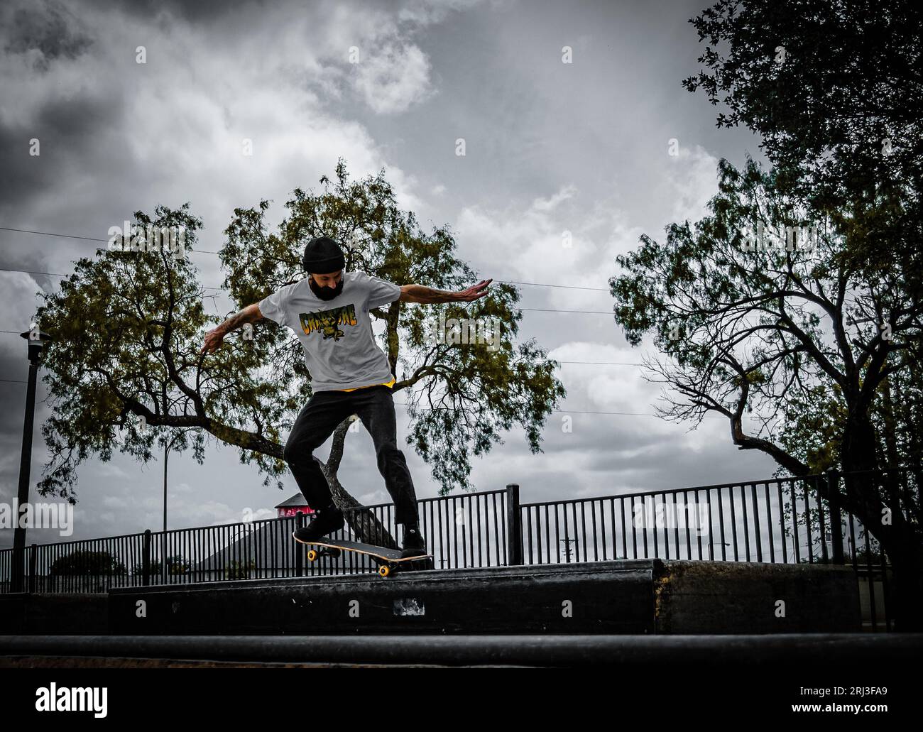 Un jeune skateboarder effectuant un Ollie trick, en plein air dans un parc Banque D'Images