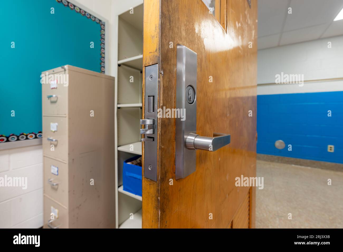 Ouvrez la porte de la salle de classe avec une nouvelle quincaillerie de porte avec des verrous de sécurité pour un verrouillage. Banque D'Images