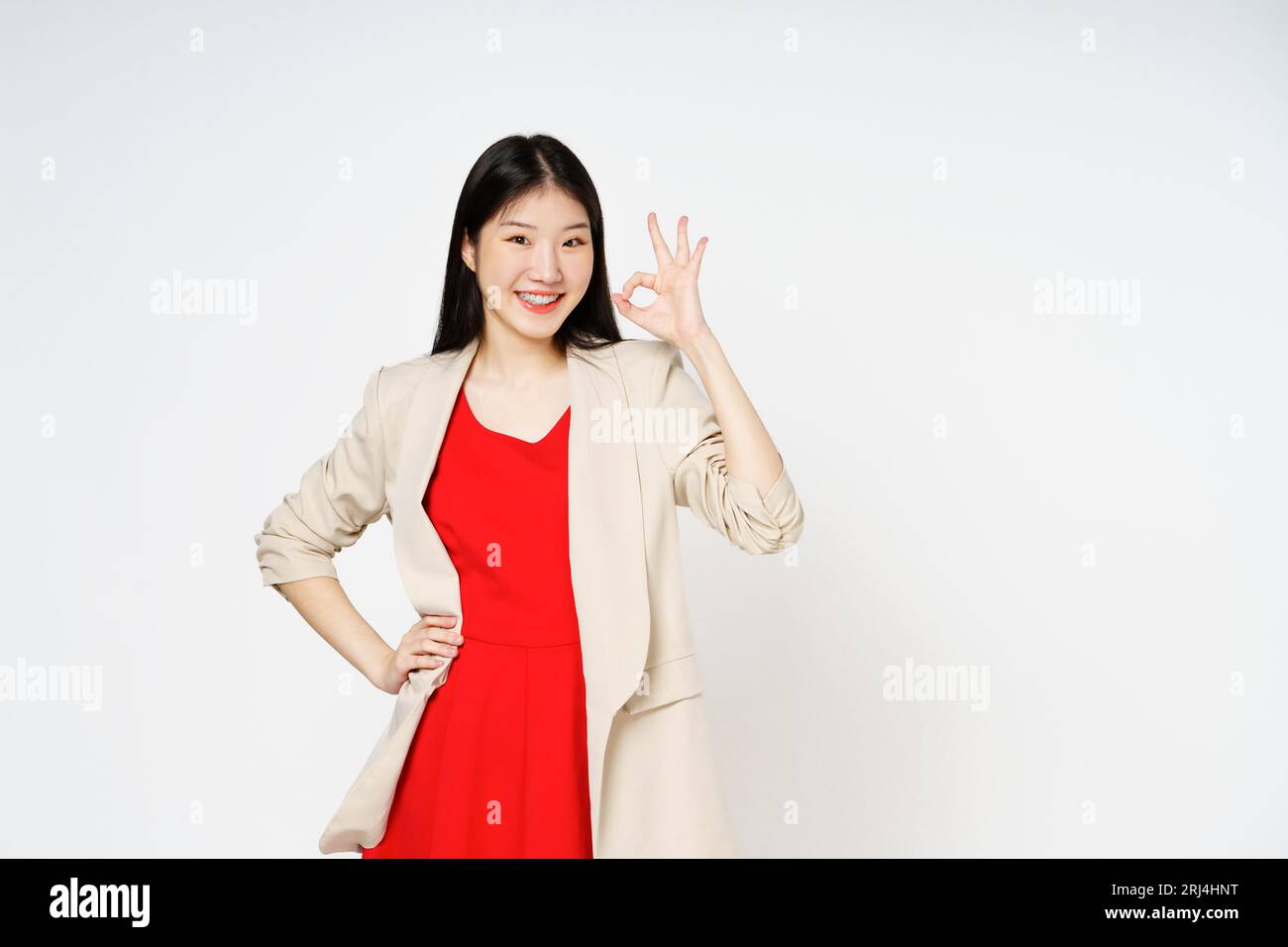 Jeune femme souriant et montrant le signe ok isolé sur fond blanc. Banque D'Images