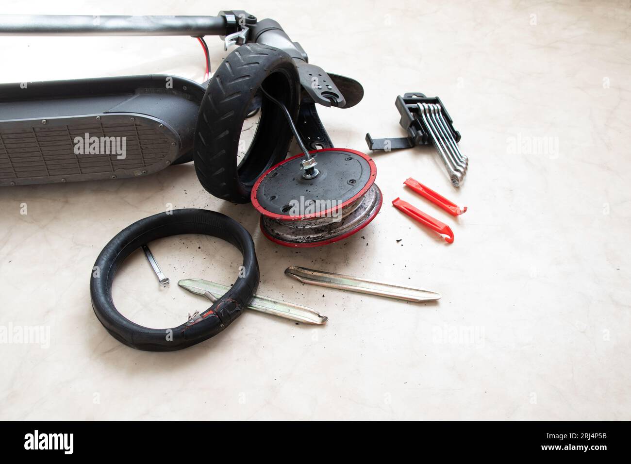 Scooter électrique démonté, crevaison de roue et remplacement par une nouvelle roue, réparation de transport électrique et services Banque D'Images