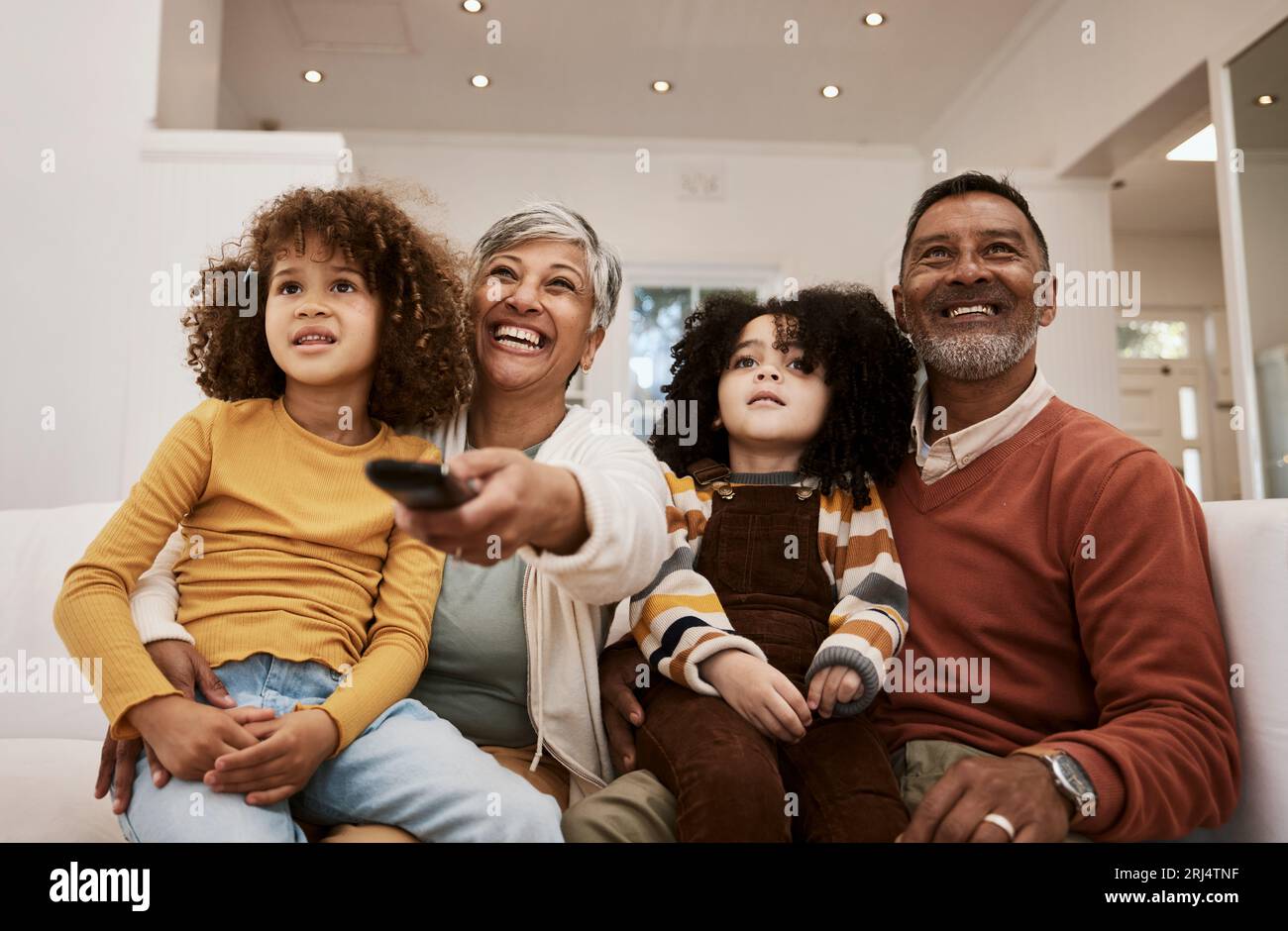 À la maison, les enfants et les grands-parents regardent des séries télévisées, des films par abonnement ou des vidéos en streaming, des médias ou des divertissements. Canapé salon, famille ou détente Banque D'Images